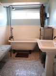 Bathroom with claw foot tub and marble tile floor
